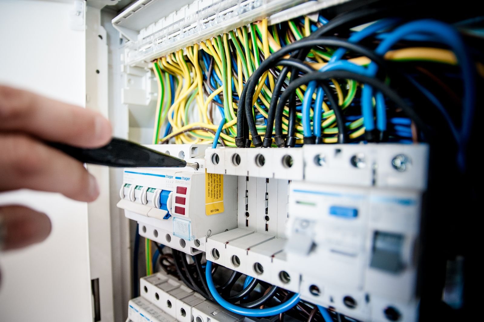 Electrician working inside an electrical switchboard
