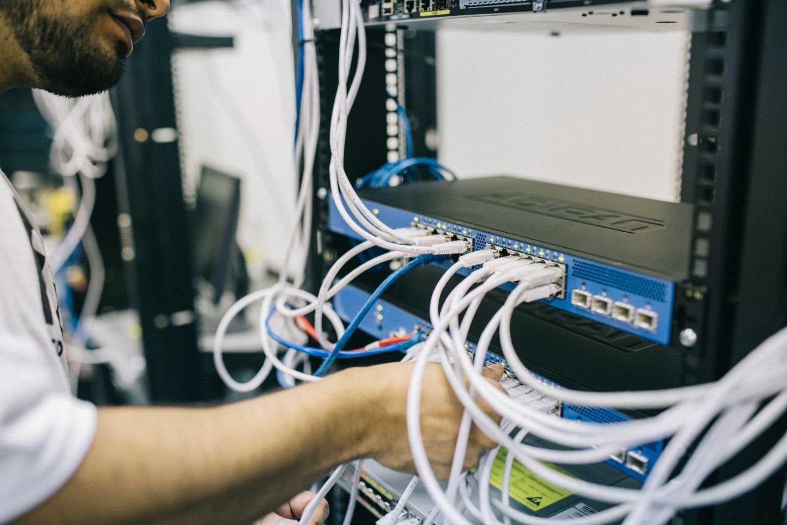 Network technician installing and organising communications cabling