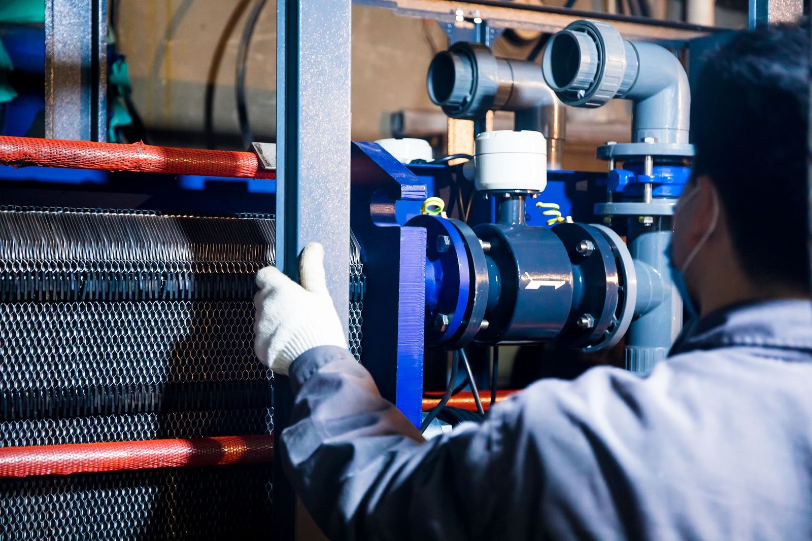 Technician inspecting industrial plant machinery