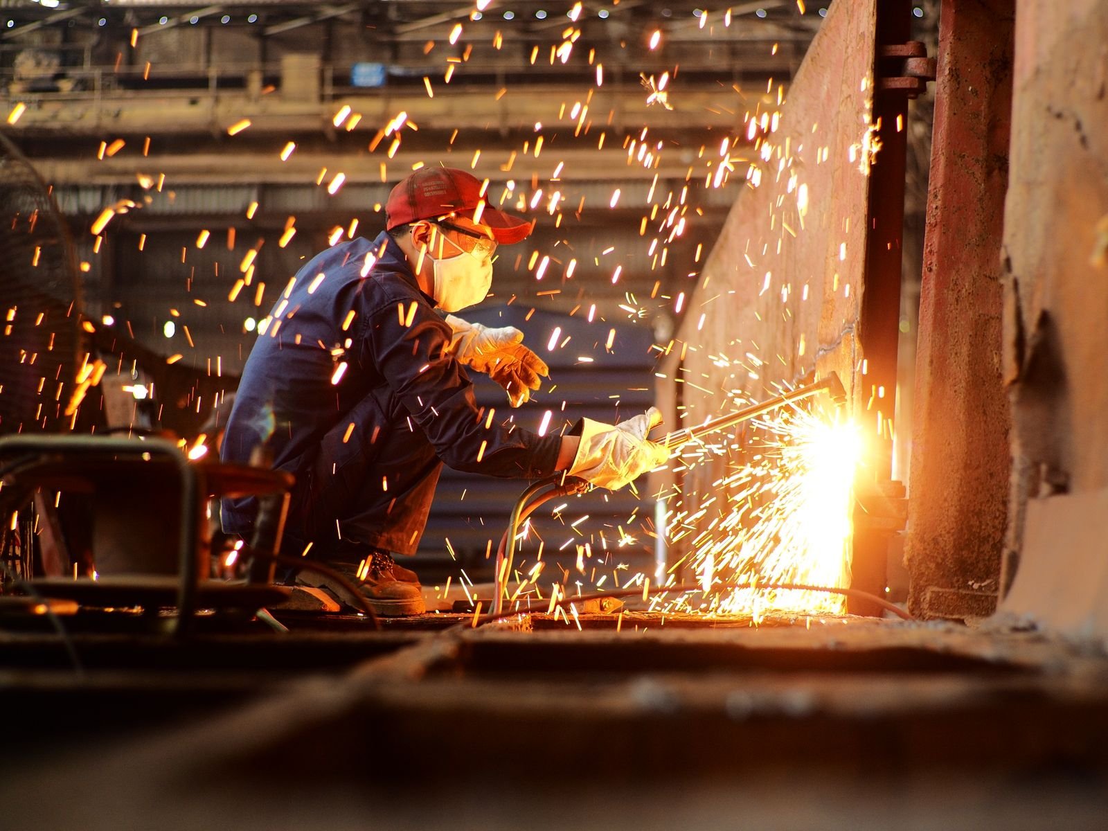 Industrial welder fabricating steel in a workshop